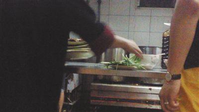 7月23日，漢麗軒烤肉超市昌平店，服務(wù)員將幾盤顧客剩菜（左手中疊在一起的是幾盤肉，其右手正整理韭菜）端回后廚，進(jìn)行整理后準(zhǔn)備再送往餐廳自助取餐區(qū)供顧客食用。